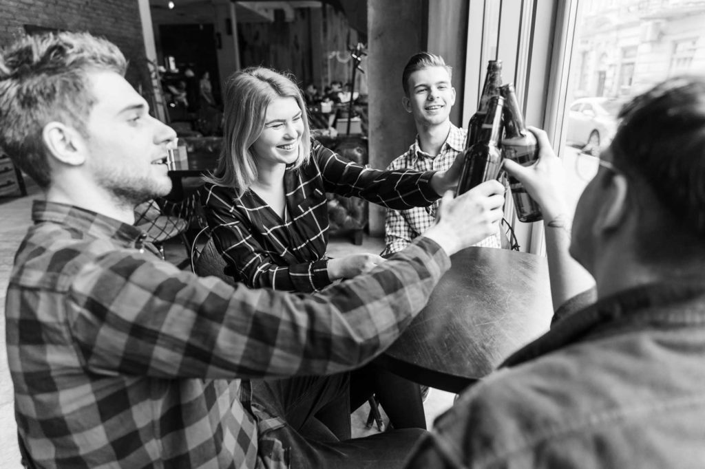 Birthday Party Pub Crawl – Header Image a group of people looking at a person holding a guitar