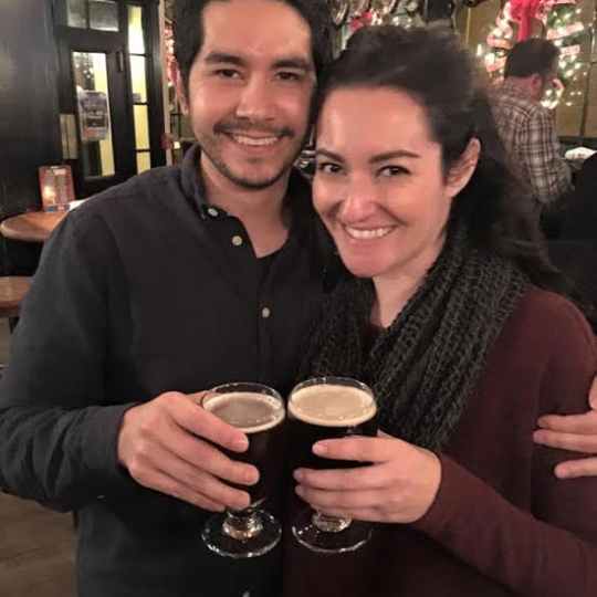 a man and a woman smiling and holding a glass of wine