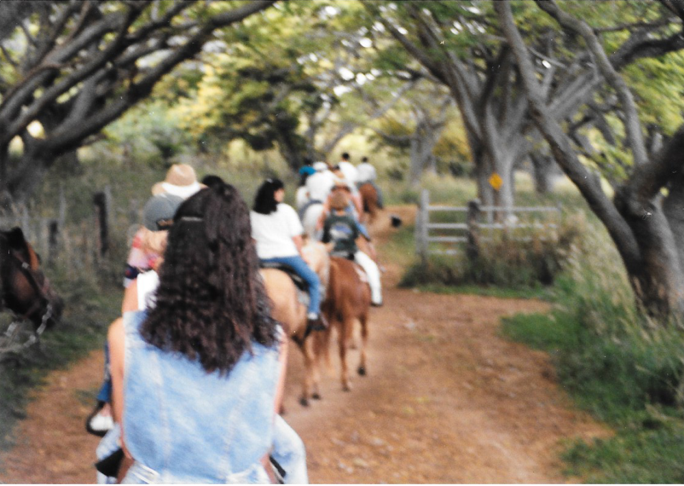 a group of people walking down a dirt road